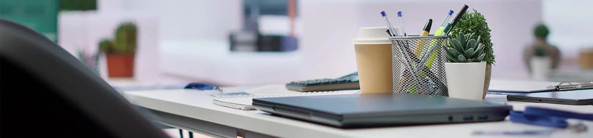 Modern Office Desk Workspace Modern office desk setup with laptop, stationery, coffee, and plant at Prozensoft Technologies